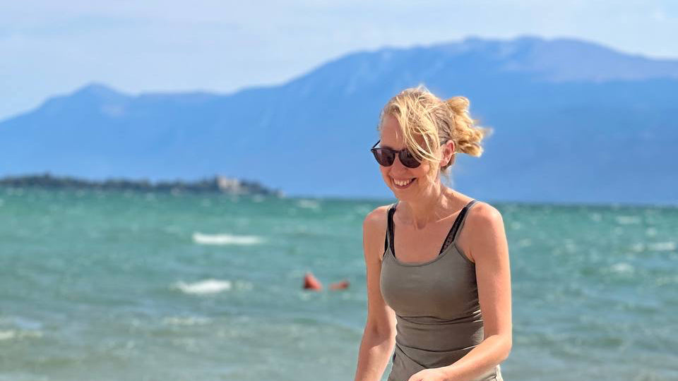 Tanja, the artist behind MidMonty, smiling at the beach – AI Art creator & resilience warrior.