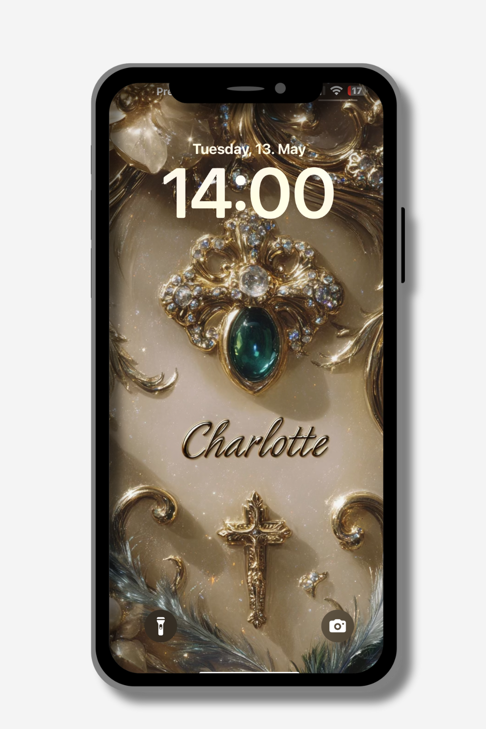 A smartphone displays a personalized lock screen wallpaper. The design features ornate gold and silver embellishments, including a jeweled centerpiece with a large emerald, a golden cross, and swirling decorative elements. The name "Charlotte" is written in elegant cursive script. The date "Tuesday, 13. May" and the time "14:00" are visible at the top. Icons for flashlight and camera are at the bottom.