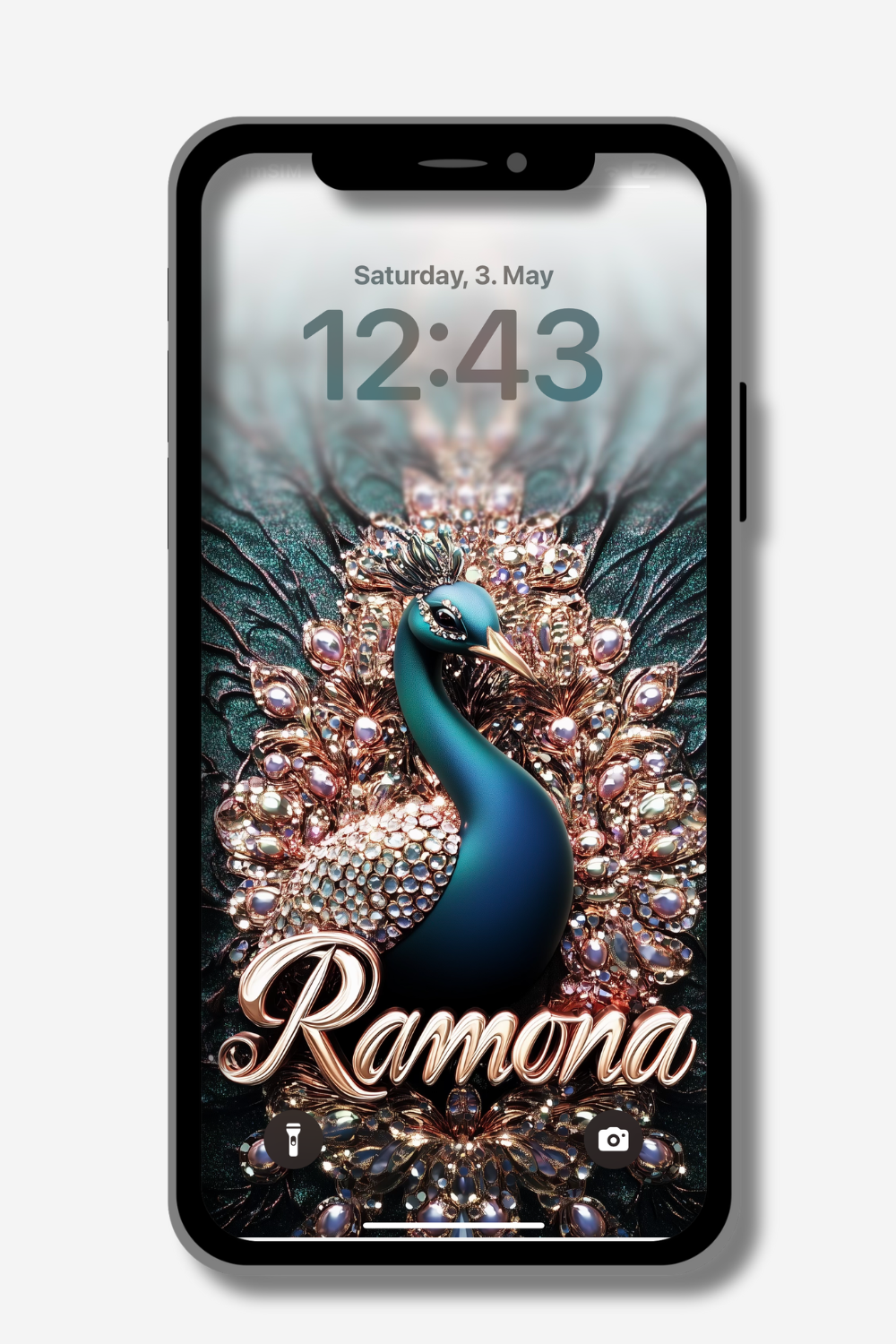 A phone screen displays a lock screen with "Saturday, 3. May" and the time "12:43". The wallpaper features a stylized, ornate peacock with teal feathers and gold accents. The name "Ramona" is written in a decorative gold script across the peacock's lower body.